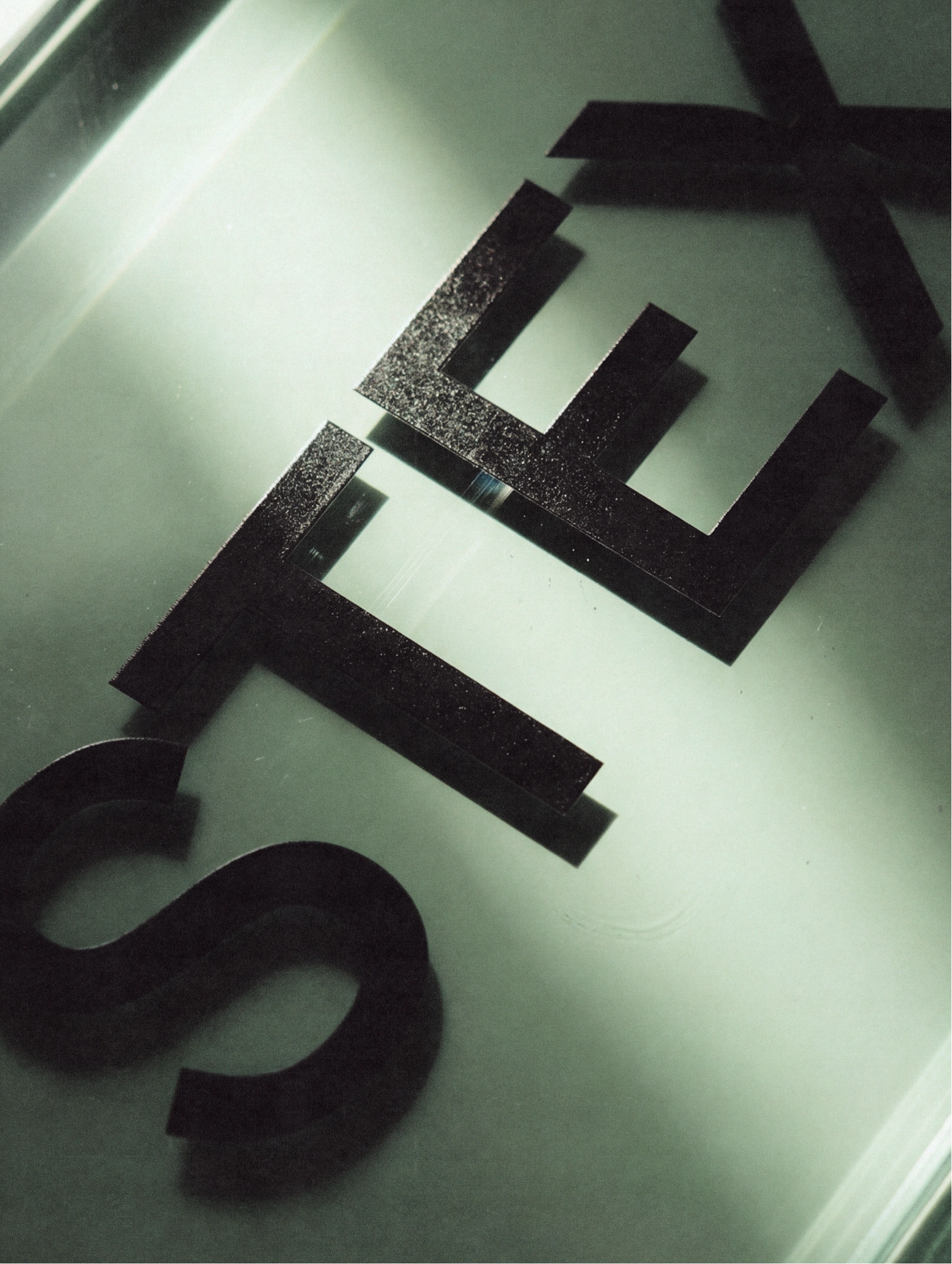 Black Stex lettering on an illuminated glass surface.