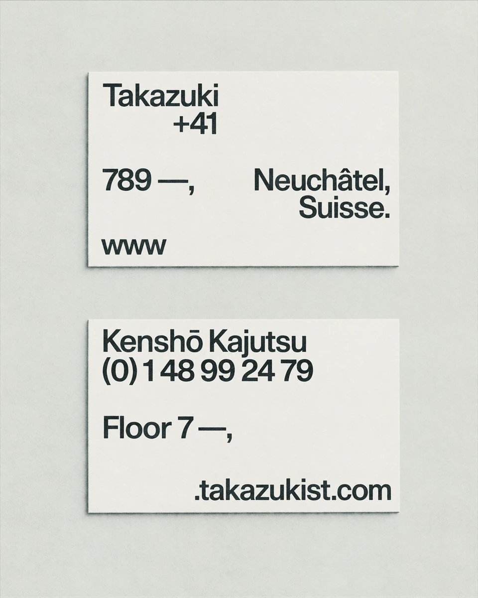 Two cream Takazuki architecture business cards with black contact details and restrained typography.
