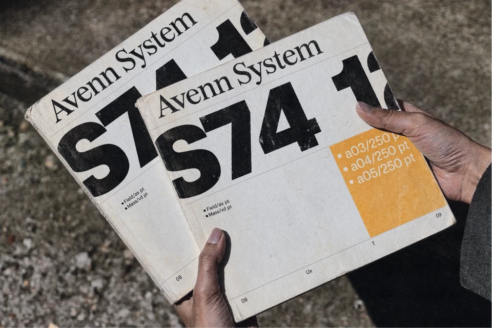 Two textured Avenn System 574 publications held in hands outdoors.