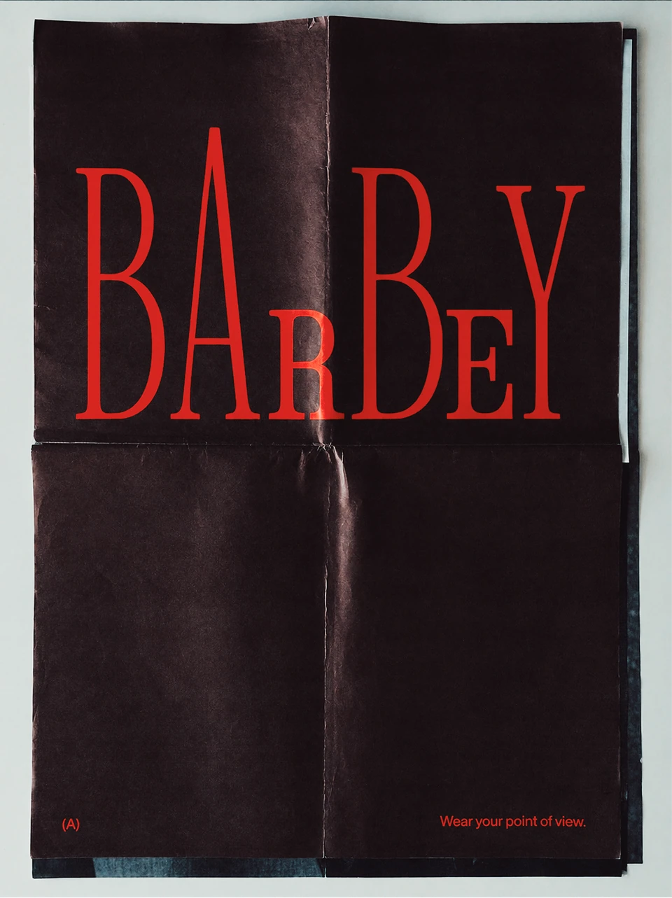 Folded dark Barbey poster with tall red serif lettering.