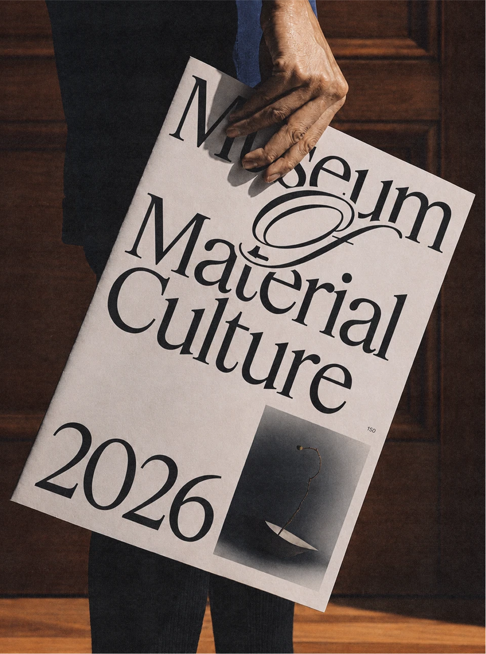 Museum of Material Culture 2026 poster held against a jacket.