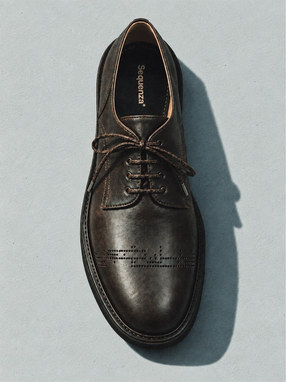 Brown leather lace-up shoe carrying the Sequenza numeric identity on its upper.