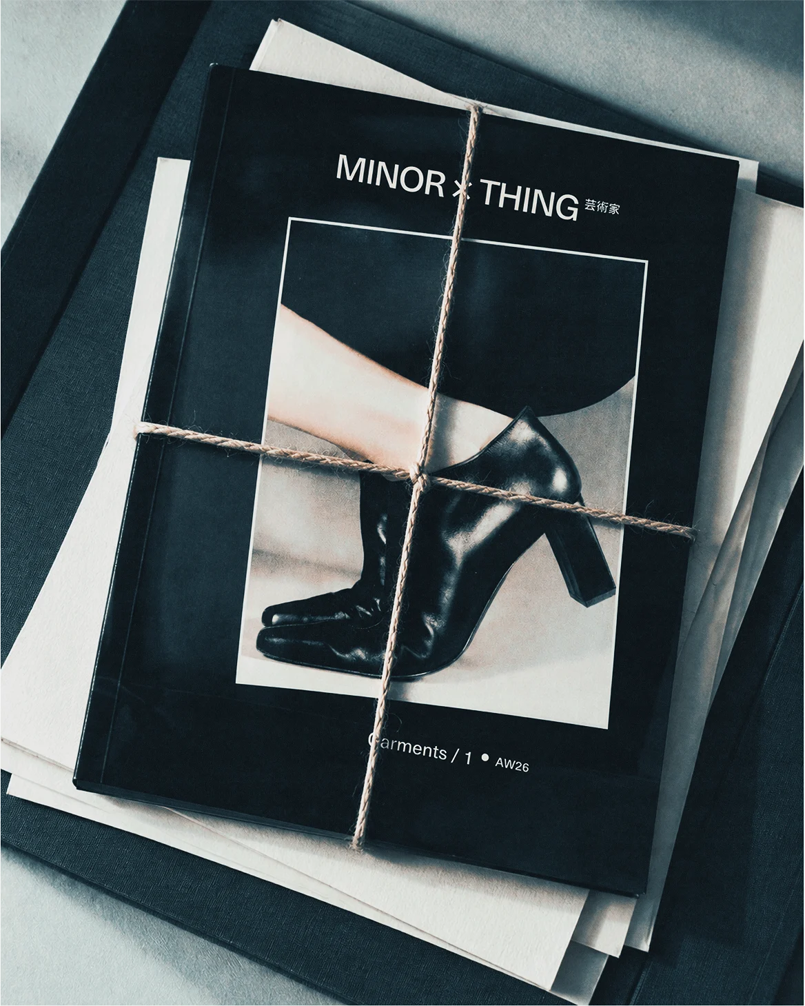 Black Minor Thing publication tied with cream string on a pale surface.