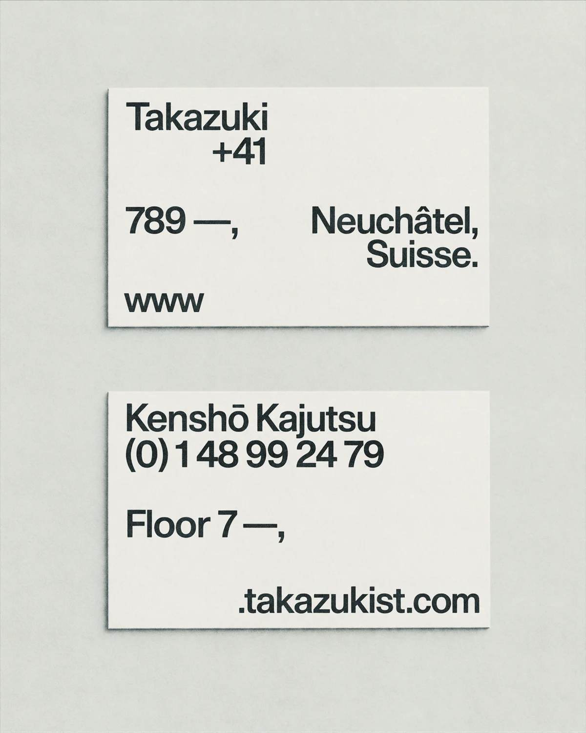 Two cream Takazuki architecture business cards with black contact details and restrained typography.